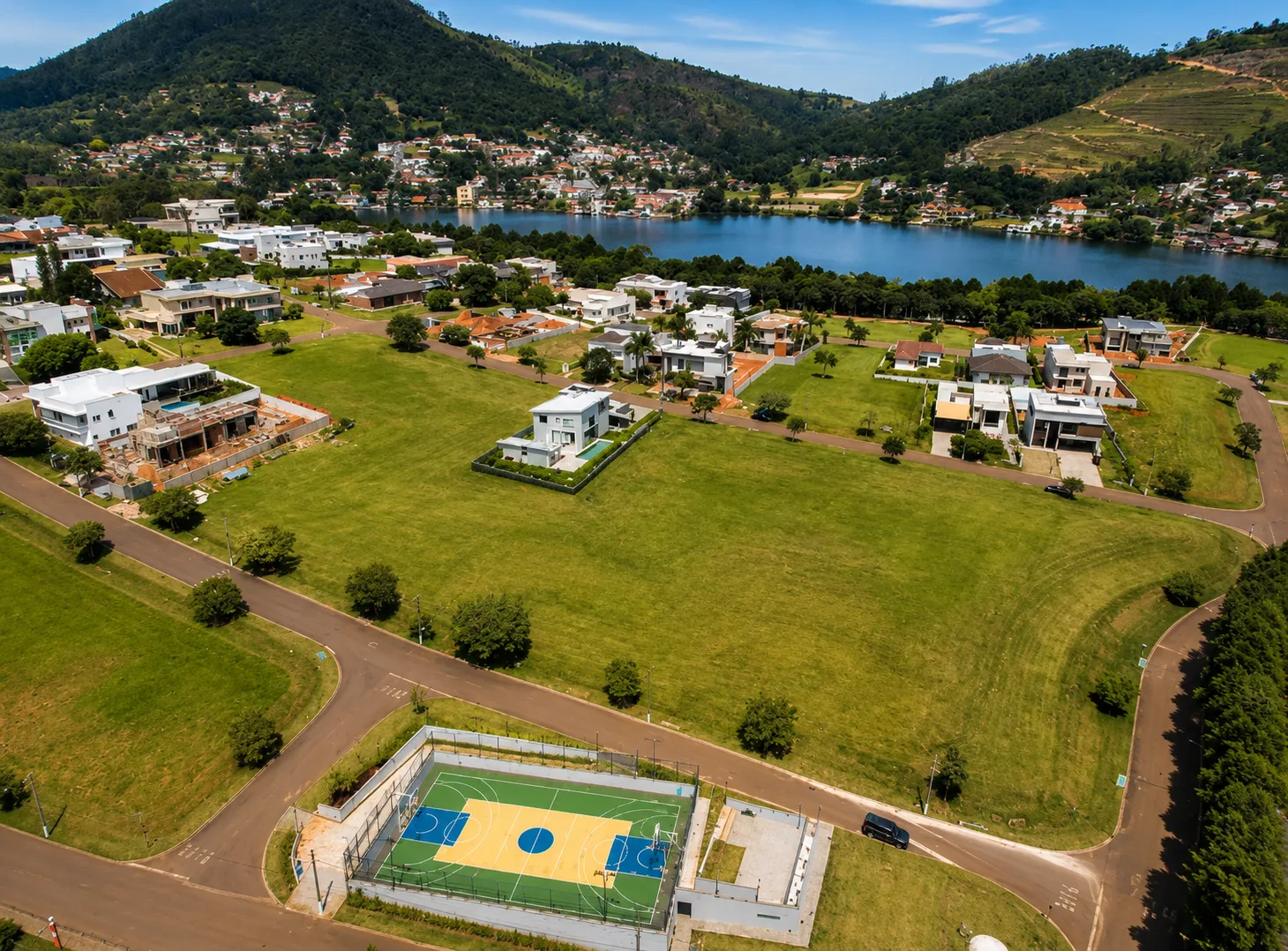 Vista aérea do Residencial Campo da Cachoeira com represa e áreas verdes