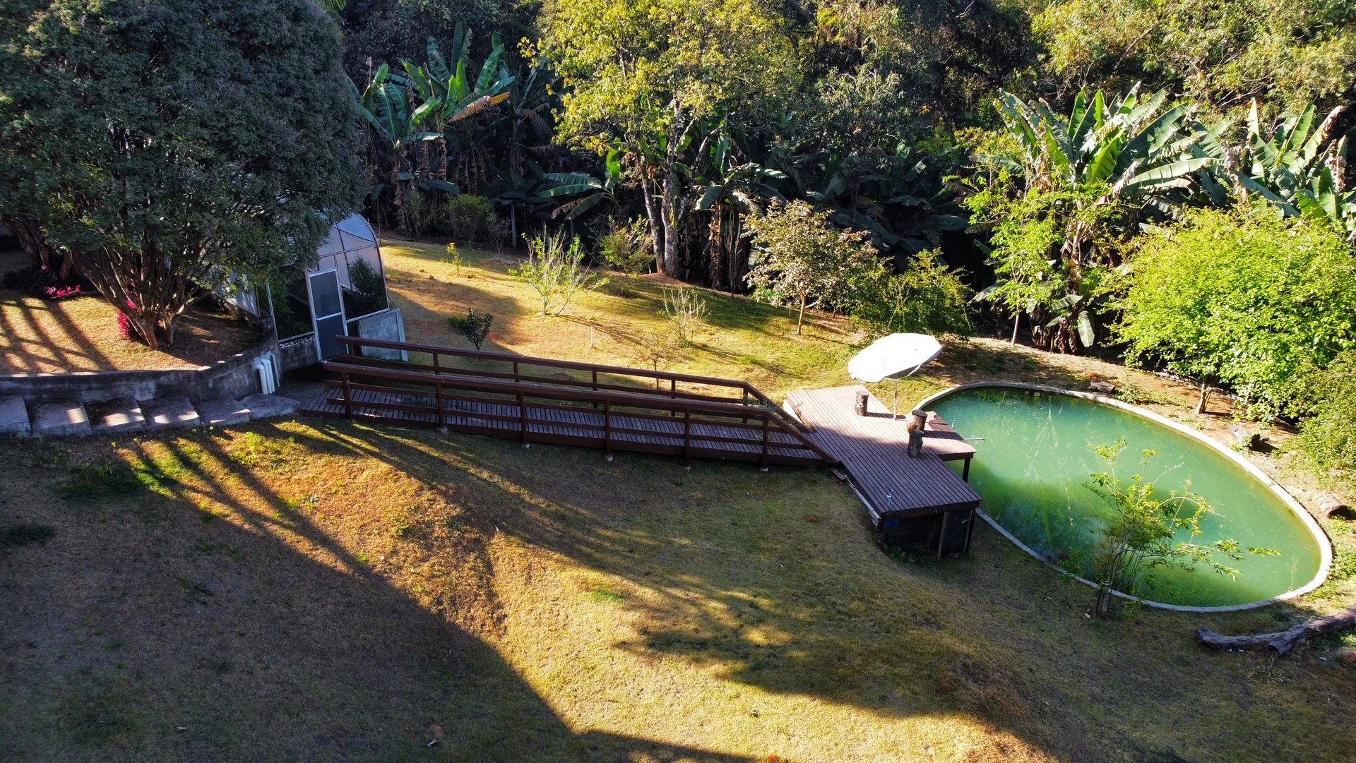 Lago, gramado e árvores na área verde da propriedade
